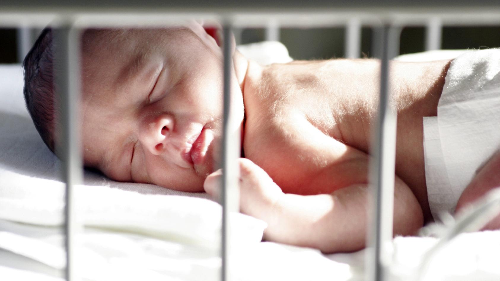 Neugeborenes schlaeft auf der Saeuglingsstation im Bett, Deutschland | newborn baby sleeping in bed at the neonatal care unit, Germany