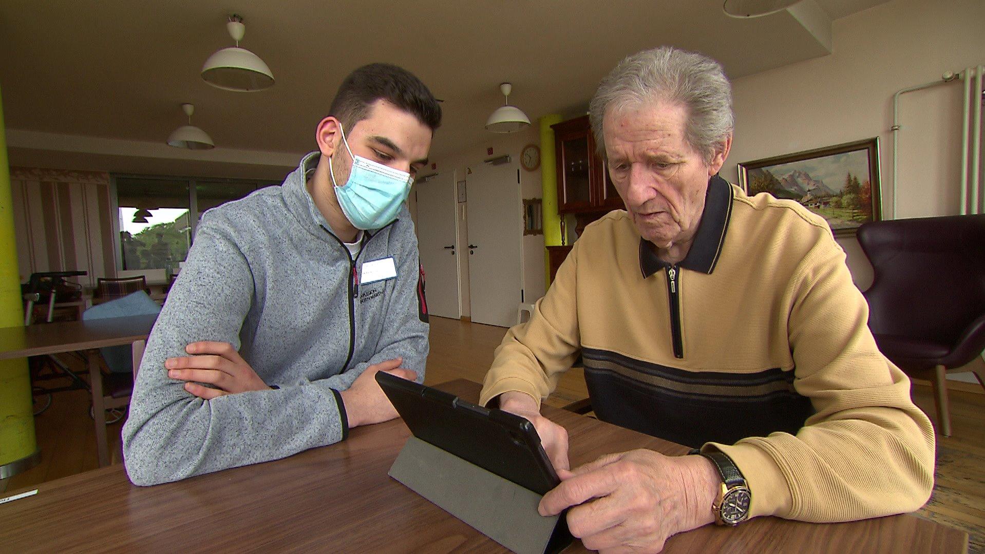 FSJler Samir bringt Rentner Achim die Nutzung des Tablets bei.