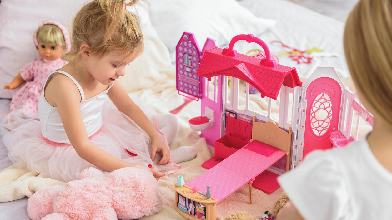 Ein Mädchen spielt mit rosa Spielzeug.