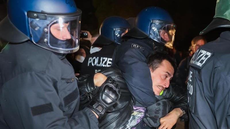 Polizisten nehmen bei der "Revolutionären 1. Mai-Demonstration" eine Person in Gewahrsam. Foto: Christoph Soeder/dpa