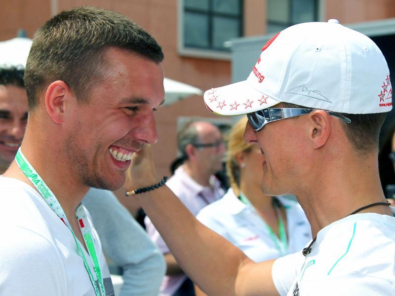 Vor dem Start war Michael Schumacher bei einem Gespräch mit Lukas Podolski noch bester Laune. Foto: Jens Buettner