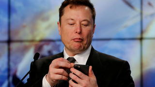 FILE PHOTO: Elon Musk looks at his mobile phone in Cape Canaveral, Florida, U.S. January 19, 2020. REUTERS/Joe Skipper/File Photo