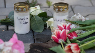 11.05.2022, Hessen, Hanau: Kerzen und Blumen erinnern nach dem gewaltsamen Tod zweier Kinder auf dem Innenhof eines Hochhauses in Hanau an die Opfer. Während die genauen Hintergründe der Tat noch unklar sind, geht die Polizei von einem familiären Hintergrund aus und fahndet nach einem Tatverdächtigen. Foto: Boris Roessler/dpa +++ dpa-Bildfunk +++
