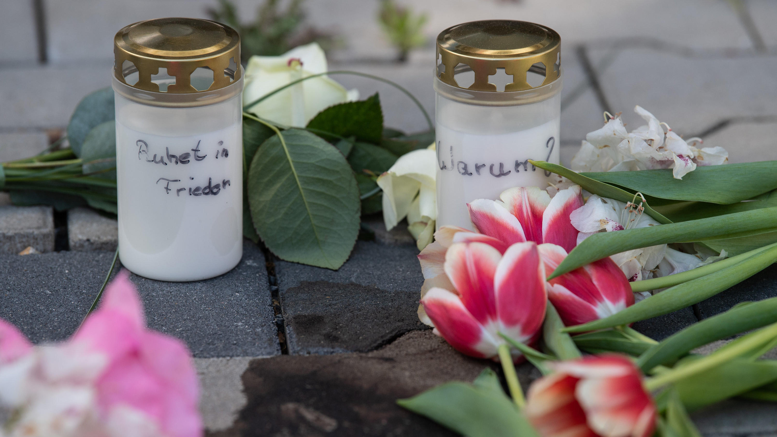 11.05.2022, Hessen, Hanau: Kerzen und Blumen erinnern nach dem gewaltsamen Tod zweier Kinder auf dem Innenhof eines Hochhauses in Hanau an die Opfer. Während die genauen Hintergründe der Tat noch unklar sind, geht die Polizei von einem familiären Hin
