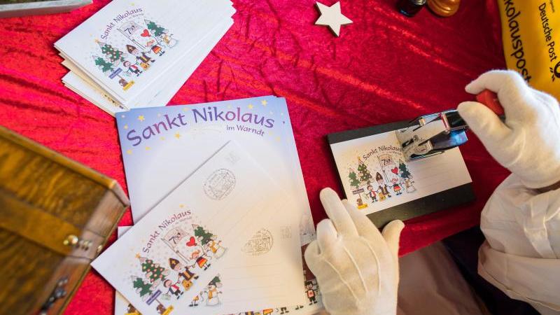 Der Nikolaus stempelt in der Nikolaushütte einen Brief ab