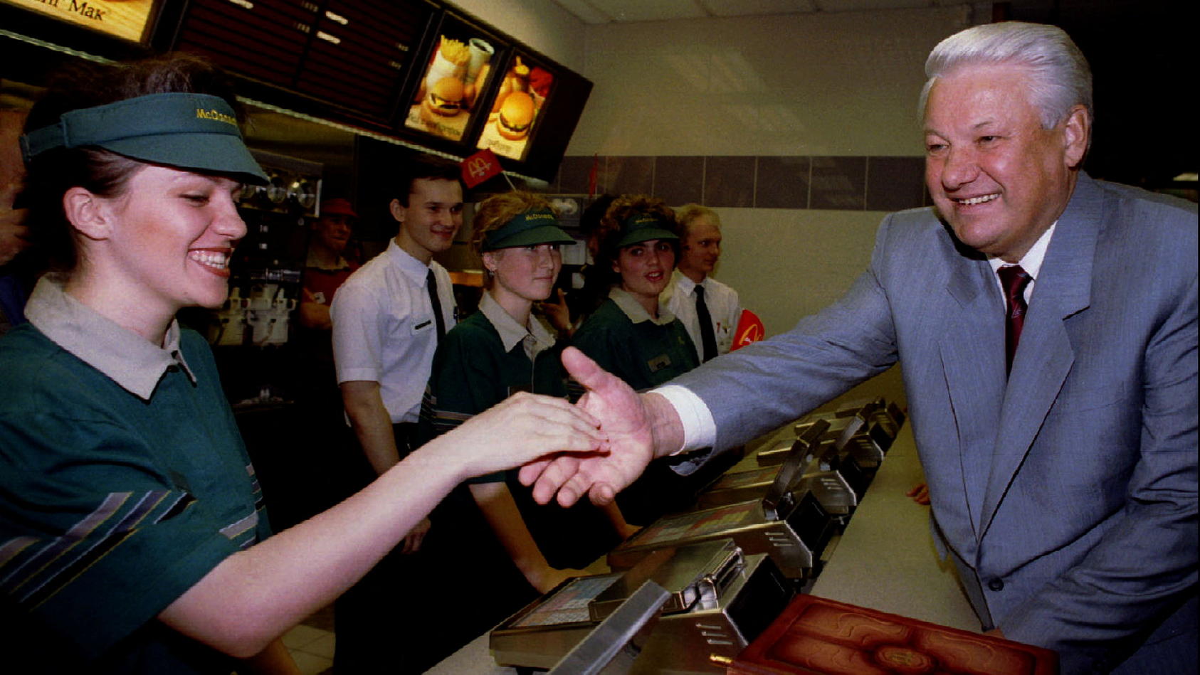 Der russische Präsident Boris Jelzin begrüßt im Jahr 1990 Mitarbeiterinnen und Mitarbeiter eines McDonald's-Restaurants bei der Eröffnung.