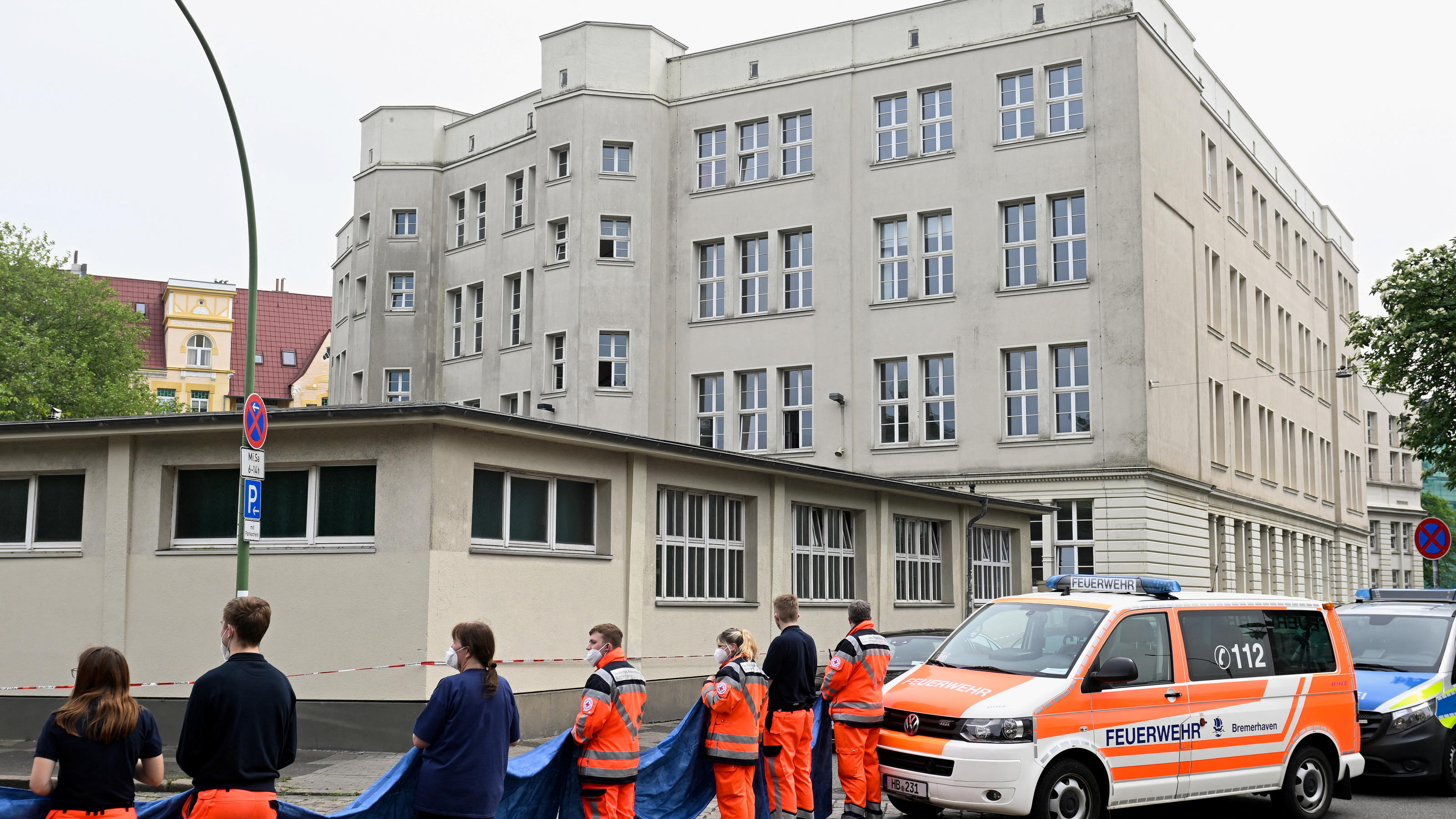 Emergency medical workers stand near a German school building where shots were fired, in the northern city of Bremerhaven, Germany, May 19, 2022. REUTERS/Fabian Bimmer