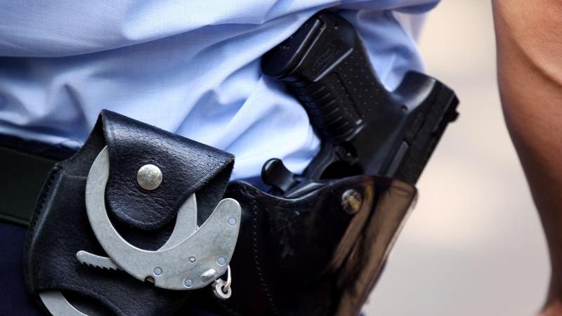 ein-polizist-tragt-handschellen-und-seine-dienstwaffe-bei-sich-foto-oliver-bergdpasymbolbild