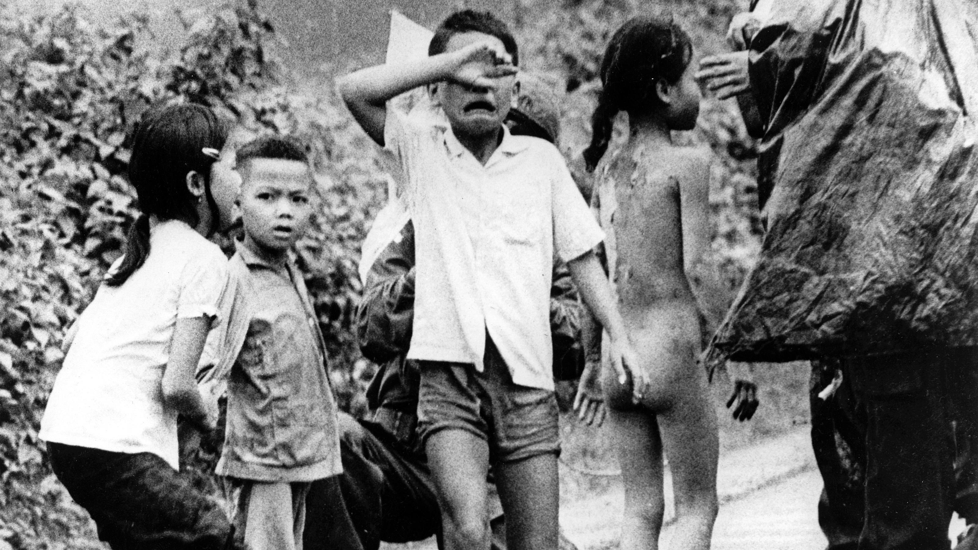 Verletzte vietnamesische Kinder weinen nach einem Napalm-Angriff auf ihr Dorf. Rechts hat sich das am ganzen Körper verbrannte Mädchen Kim Phuc seine Kleidung vom Leib gerissen. Aufnahme von 1972. Eine andere Fotosequenz der damals neunjährigen Kim P