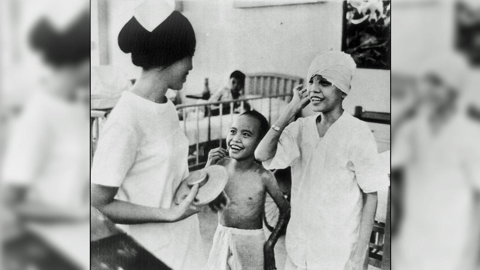 Kim Phuc, center, and a friend, Nguyen Thi Thu, chat with a Vietnamese nurse at the Barsky Center for Plastic and Reconstructive Surgery in Saigon, where both youngsters are being treated, Aug. 8, 1972. Kim Phuc was burned by an accidental napalm str