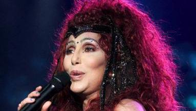 Cher bei einem ihrer Konzerte mit roten Haaren und Glitzersteinen auf der Stirn