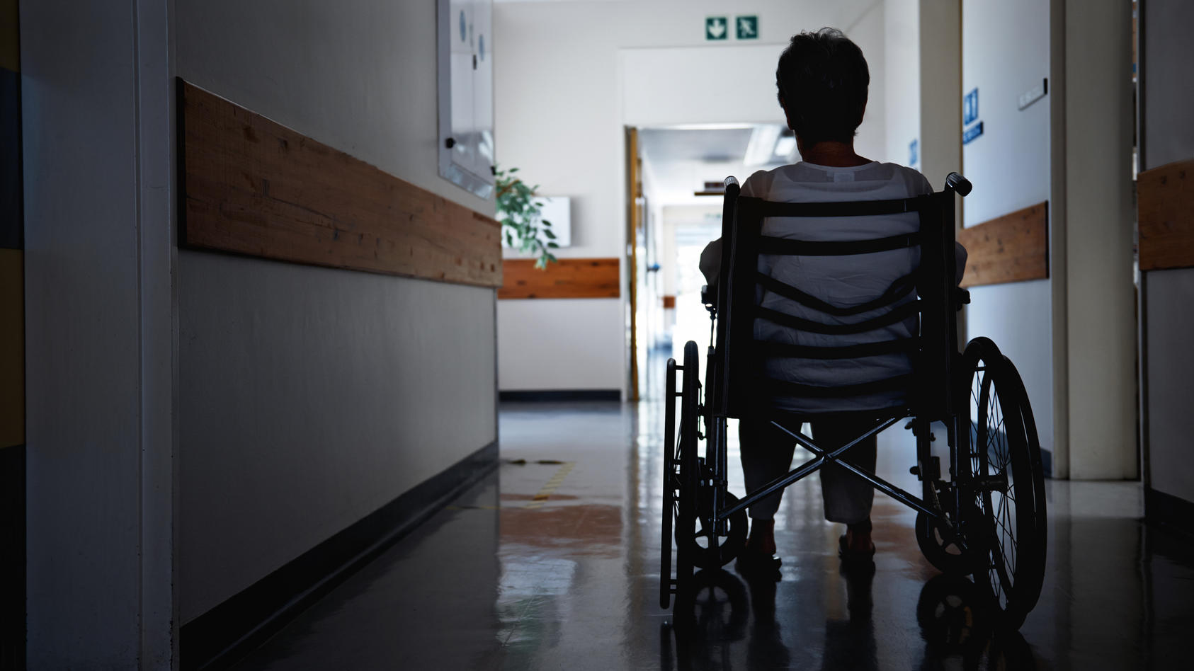 Ältere Frau sitzt im Rollstuhl im Pflegeheim