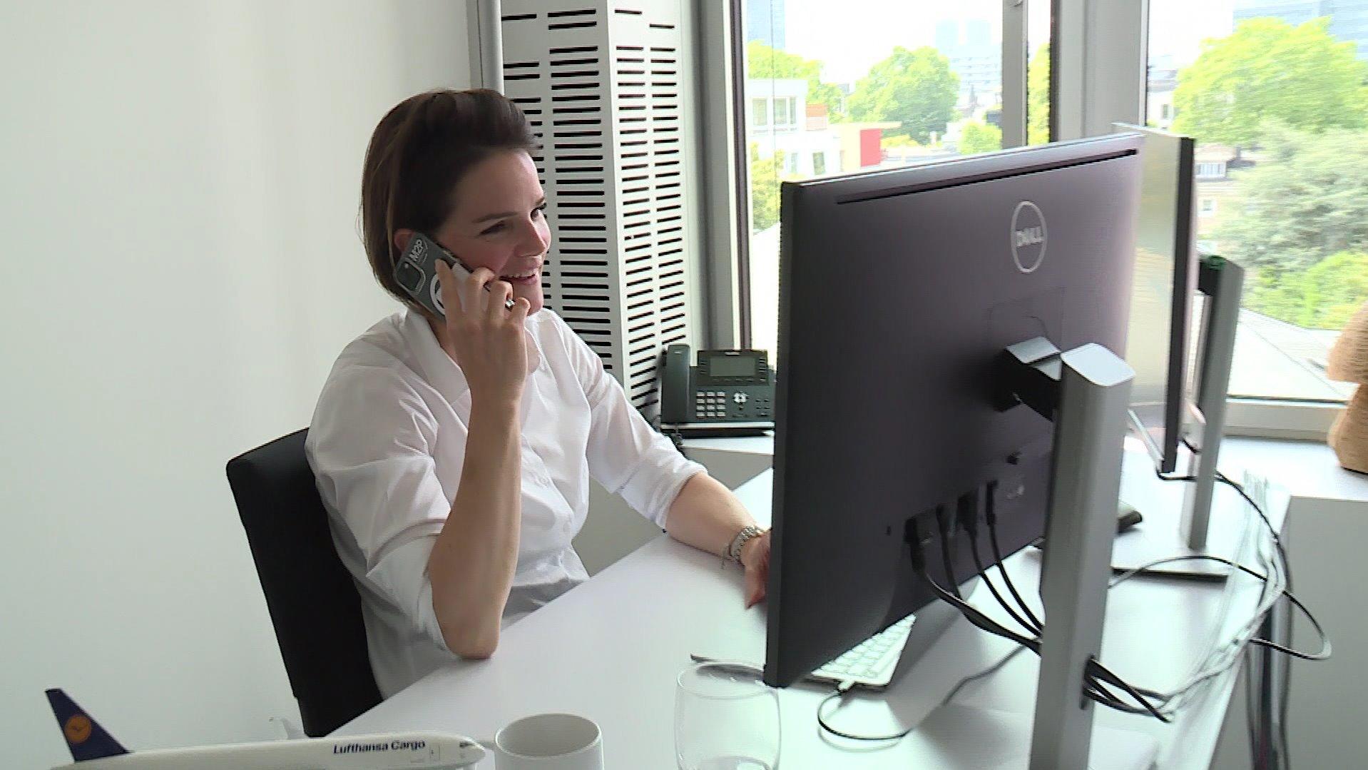 Lana Jansen telefoniert am Arbeitsplatz.