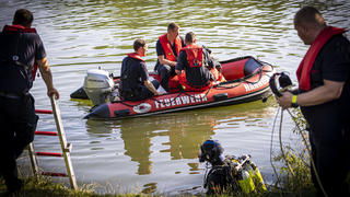 30.06.2022, Niedersachsen, Hannover: Einsatzkräfte sind in einem Boot im Wasser vom Dreiecksteich unterwegs. In dem Baggersee ist ein Mann ertrunken. Foto: Moritz Frankenberg/dpa +++ dpa-Bildfunk +++