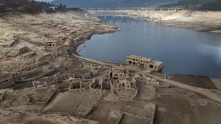 FILE -  Parts of the old village of Aceredo, submerged three decades ago when a hydropower dam flooded the valley, which reemerged due to drought at the Lindoso reservoir, in northwestern Spain, Saturday, Feb. 12, 2022. Spain is breathing a sigh of relief as a sharp drop in temperatures is helping firefighters contain wildfires across the country that destroyed tens of thousands of acres of wooded land. (AP Photo/Emilio Morenatti, File)