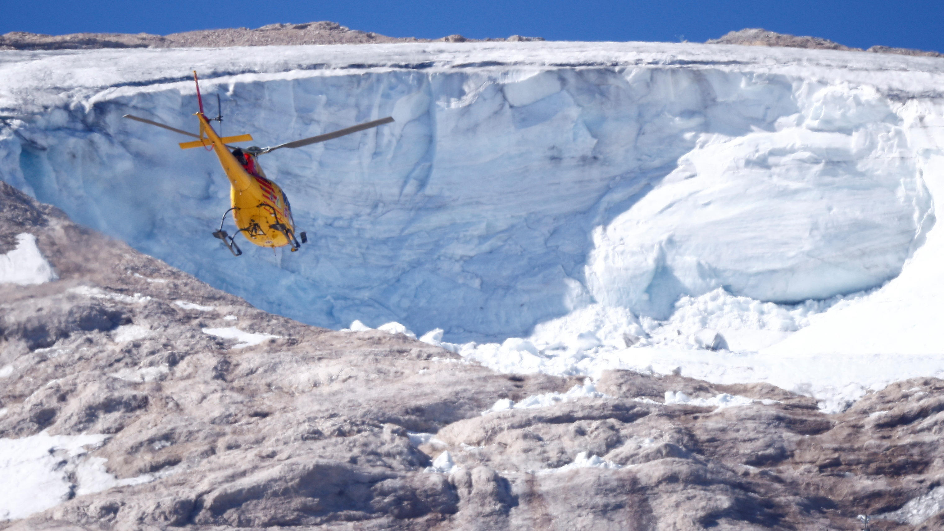 A helicopter participates in a search and rescue operation over the site of a deadly collapse of parts of a mountain glacier in the Italian Alps amid record temperatures, at Marmolada ridge, Italy July 6, 2022. REUTERS/Guglielmo Mangiapane  ?