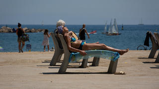 13.07.2022, Spanien, Barcelona: Mehrere Personen sonnen sich am Strand von Barceloneta. Die Temperaturen in Spanien klettern angesichts der aktuellen Hitzewelle auf Spitzenwerte. Foto: David Zorrakino/EUROPA PRESS/dpa +++ dpa-Bildfunk +++