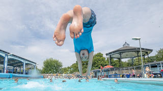 17.07.2022, Großbritannien, Hathersage: Ein Junge springt in ein Schwimmbecken im Freibad von Hathersage. Die Temperaturen in Hathersage steigen in den kommenden Tagen auf über 30 Grad Celsius. Foto: Danny Lawson/PA Wire/dpa +++ dpa-Bildfunk +++