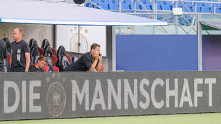 Oliver Bierhoff am Telefon, davor auf der Bander der Schriftzug "Die Mannschaft",