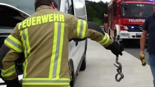 Die Feuerwehr Groß Ippener holt eine Kornnatter aus dem Motorraum eines Transporters.