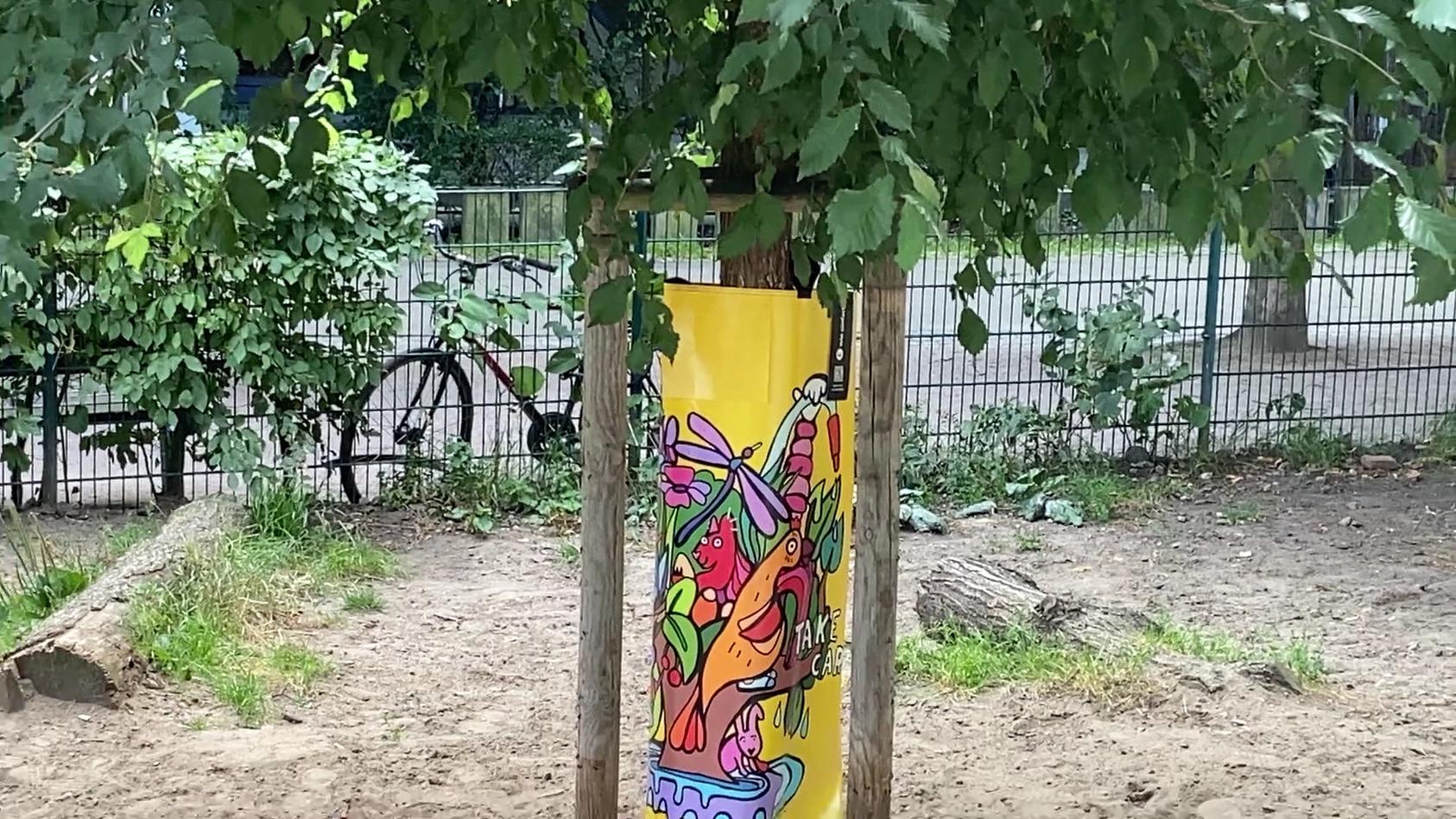 In Hamburg haben Straßenkünstler Baumbewässerungssäcke individuell gestaltet.