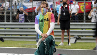 ARCHIV - 01.08.2021, Ungarn, Mogyorod: Motorsport: Formel-1-Weltmeisterschaft, Großer Preis von Ungarn, Rennen: Sebastian Vettel aus Deutschland vom Team Aston-Martin kniet vor dem Rennen auf der Rennstrecke zur Unterstützung der Black-Lives-Matter-Bewegung nieder und trägt eine T-Shirt in Regenbogenfarben. Sebastian Vettel wird keinen neuen Vertrag bei Aston Martin unterschreiben und seine Formel-1-Karriere nach dieser Saison beenden. Das teilte der 35 Jahre alte viermalige Weltmeister am Donnerstag in Budapest mit. (zu dpa «Formel 1: Rücktritt von Sebastian Vettel nach dieser Saison») Foto: Florion Goga/Pool Reuters/AP/dpa +++ dpa-Bildfunk +++