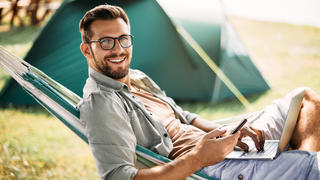 Camper mit Handy und Laptop.