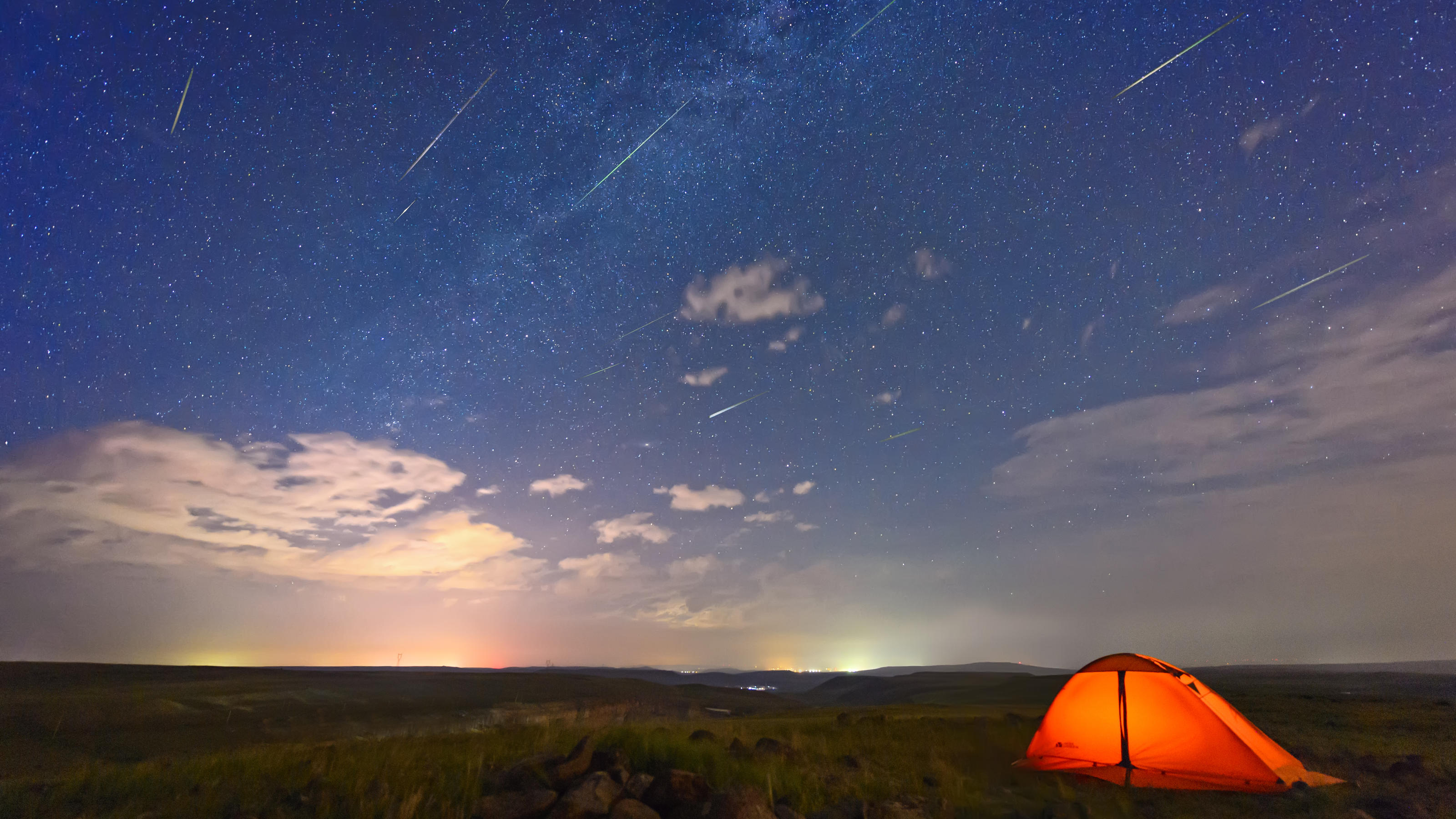 Perseiden-Meteorstrom am Nachthimmel mit Zelt
