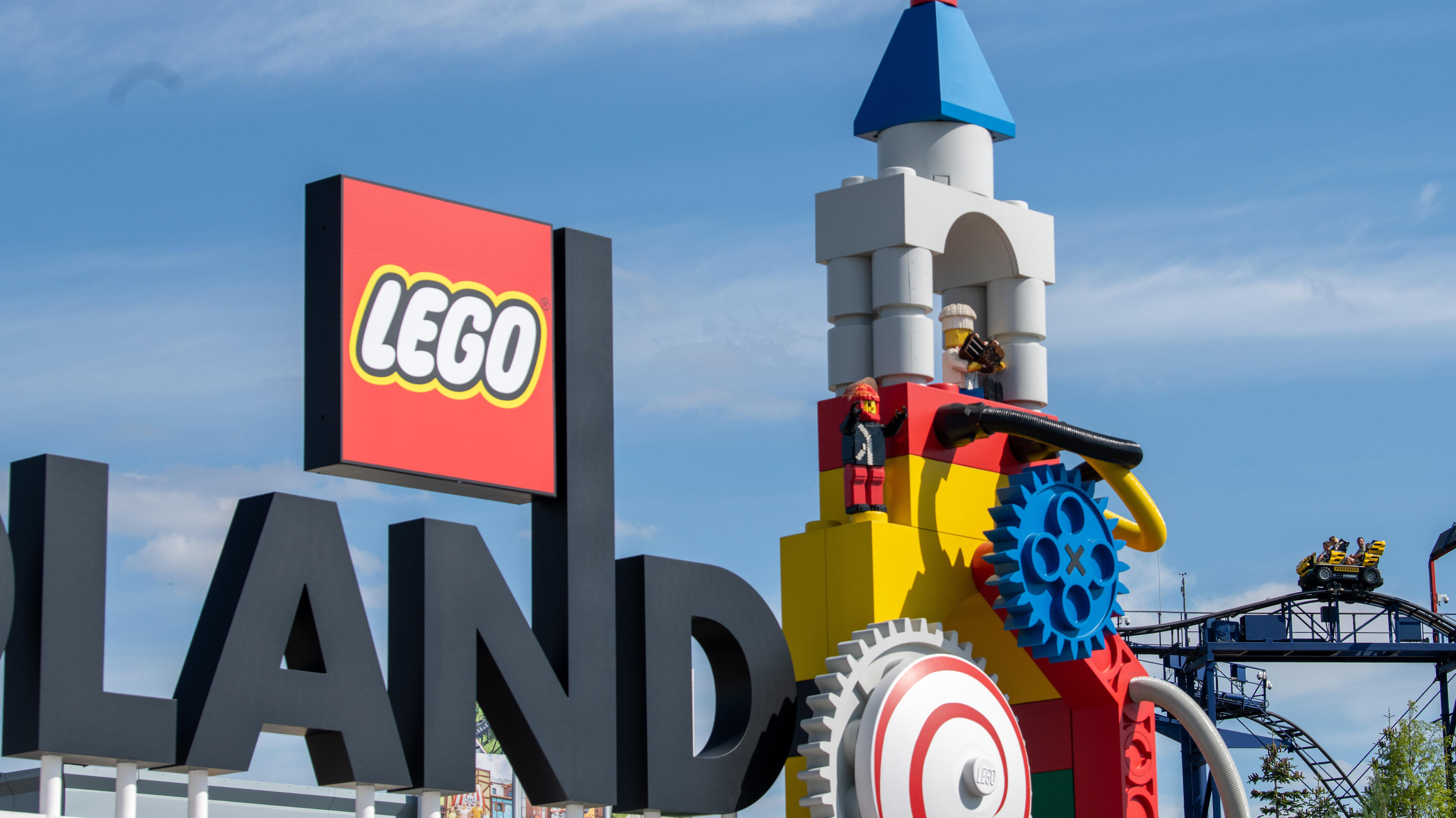 Neben dem Logo am Eingang zum Legoland ist eine Achterbahn zu sehen. Bei dem Unfall auf einer Achterbahn im Legoland im schwäbischen Günzburg sind mindestens 34 Menschen verletzt worden, zwei davon schwer.