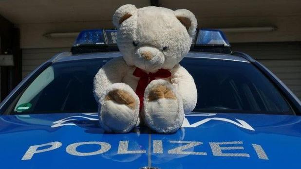 HANDOUT - 12.08.2022, Baden-Württemberg, Mannheim: Ein auf der Autobahn 6 gefundener Teddybär sitzt auf einem Polizeiauto. Die Beamten haben das Stofftier nach einer Rettungsaktion zurückgegeben. (zu dpa: «Polizei rettet Teddy von Autobahn - Besitzer