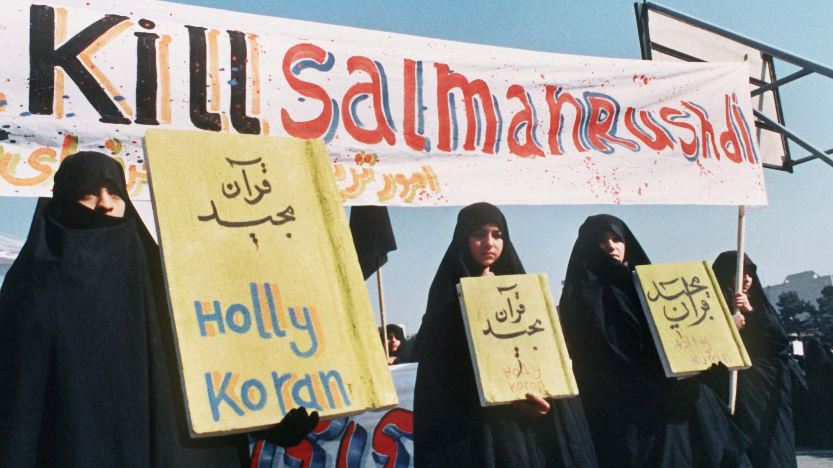 Kill Salman Rushdie ist auf einem Spruchband zu lesen, das iranische Frauen (Archivbild vom 17.2.1989) in Teheran bei einer Demonstration gegen den britischen Schriftsteller Salman Rushdie und sein Buch Satanische Verse mit sich führen. Der iranische