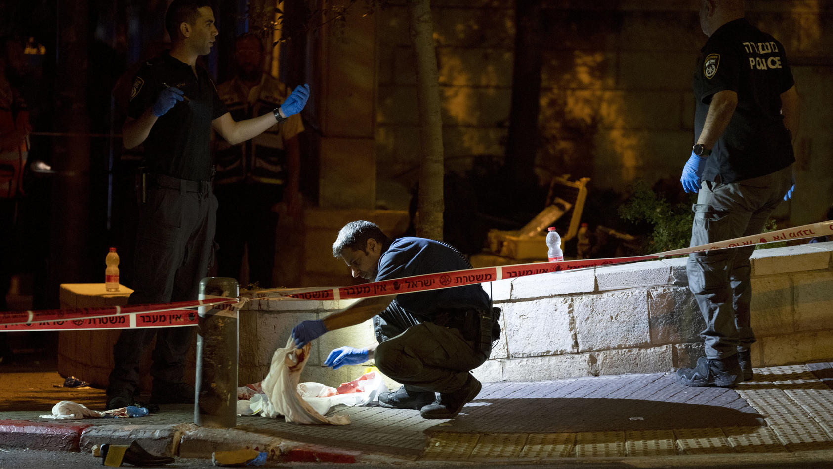 Israeli police crime scene investigators work at the scene of a shooting attack that wounded several Israelis near the Old City of Jerusalem, early Sunday, Aug. 14, 2022. Israeli police and medics say a gunman opened fire at a bus in a suspected Pale