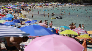 14.08.2022, Spanien, Capdepera: Menschen schwimmen und sonnen sich am Strand Cala Agulla nahe Cala Rajada auf Mallorca. Noch immer herrschen hier hohe Temperaturen und Hitzewarnungen. Foto: Clara Margais/dpa +++ dpa-Bildfunk +++