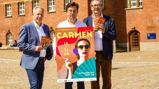 Die Premiere der Kieler Sommeroper „Carmen“ auf dem Rathausplatz. Die Theaterleitung mit dem Carmen-Plakat.
