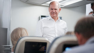 Bundeskanzler Olaf Scholz (SPD) spricht auf dem Flug mit dem Airbus A340 der Luftwaffe von Oslo nach Stockholm mit den mitreisenden Journalisten.