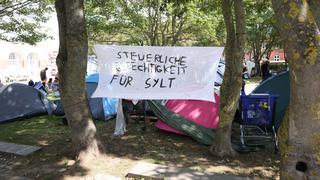  Protestcamp von Punkern und linken Aktivisten auf dem Rathausplatz in Westerland auf Sylt. Vom 1. August bis zum 14 August campieren die Gruppen von Aktion Sylt in Zelten unter dem Motto: Sylt für alle gegen Gentrifizierung und die Abschottung der Reichen auf der Lieblingsinsel der Reichen. Rund 90 Personen demonstrien auf der Urlaubsinsel Sylt unter dem Motto Sylt gehört dem Pöbel durch Westerland. Nur wenig Teilnehmerinnen und Teilnehmer folgten dem Aufruf der Hamburger Gruppe Schwarz-Roter 1. Mai, die eigentlich zum Protest gegen einen Neonazi-Aufmarsch mobilisiert hat. Nach einer Absprache zogen die Demonstraten friedlich vom Bahnhof vor das Rathaus der Nordseeinsel, wo seit einigen Tagen ein Protestcamp linker Personen und