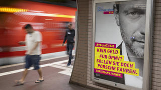 01.09.2022, Hessen, Frankfurt/Main: An ein offizielles Wahlplakat erinnert ein großflächiges Bild von FDP-Chef Christian Lindner, welches mit dem Spruch ·Kein Geld für  ÖPNV? Sollen sie doch Porsche fahren· auf dem Bahnsteig eines S-Bahnhofes in Frankfurt hängt.    (zu dpa "Werbeflächen «gekapert»: «Sollen sie doch Porsche fahren»") Foto: Boris Roessler/dpa - ACHTUNG: Nur zur redaktionellen Verwendung (bis zum 30.09.2022) im Zusammenhang mit der aktuellen Berichterstattung und nur mit vollständiger Nennung des vorstehenden Credits +++ dpa-Bildfunk +++