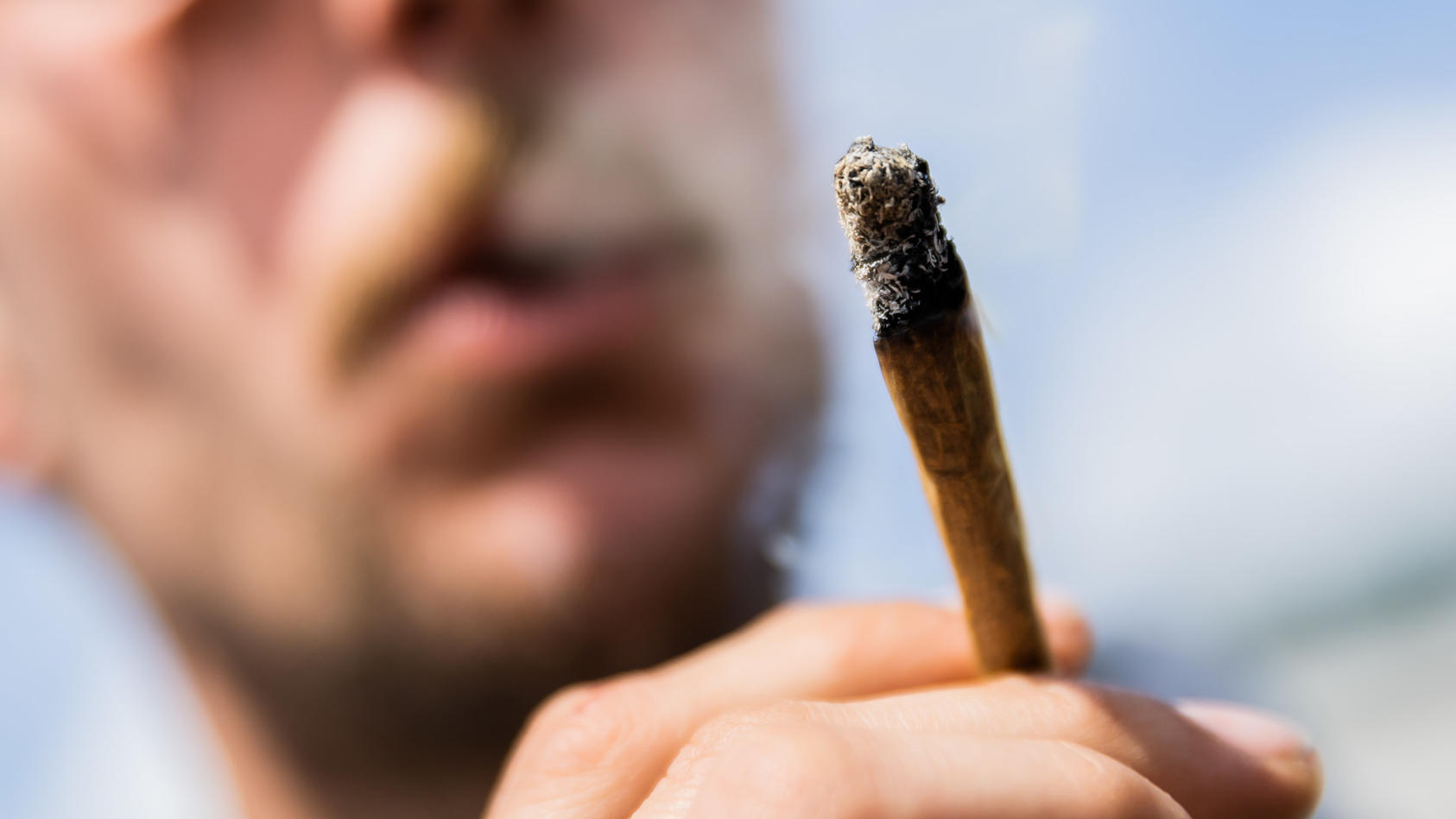 ARCHIV - 07.05.2022, Berlin: Ein Mann raucht bei einer Demonstrationen für eine Legalisierung von Cannabis im Mai 2022 am Brandenburger Tor einen Joint mit Medizinalcannabis. (zu dpa: «Gehalt von Rauschmittel THC in Haschisch verdoppelt») Foto: Chris