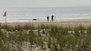 New York Police investigators examine a stretch of beach at Coney Island where three children were found dead in the surf, Monday, Sept. 12, 2022, in New York. Authorities believe the children may have been drowned by their mother. (AP Photo/Joseph Frederick)