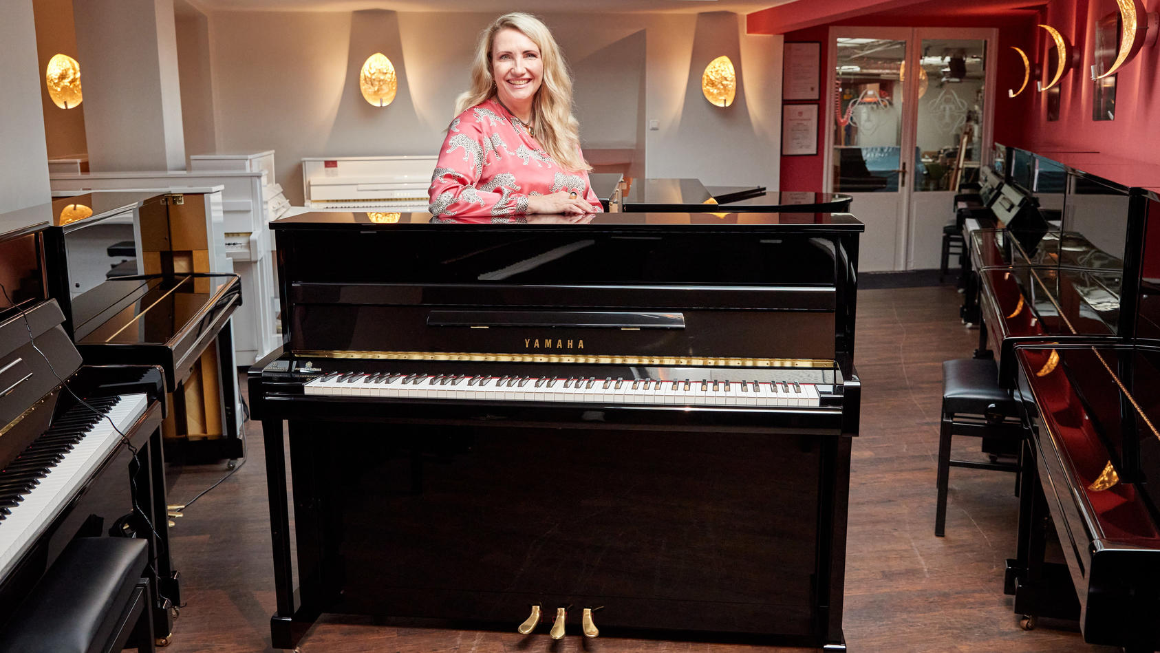 25.08.2022, Hamburg: Yvonne Trübger, Inhaberin, steht hinter einem von 15 Klavieren, das anlässlich des 150. Jubiläums des Pianohauses Trübger gespendet werden soll. Das Pianohaus gehört zu den letzten Pianohäusern, die nicht nur eine Marke vertreten