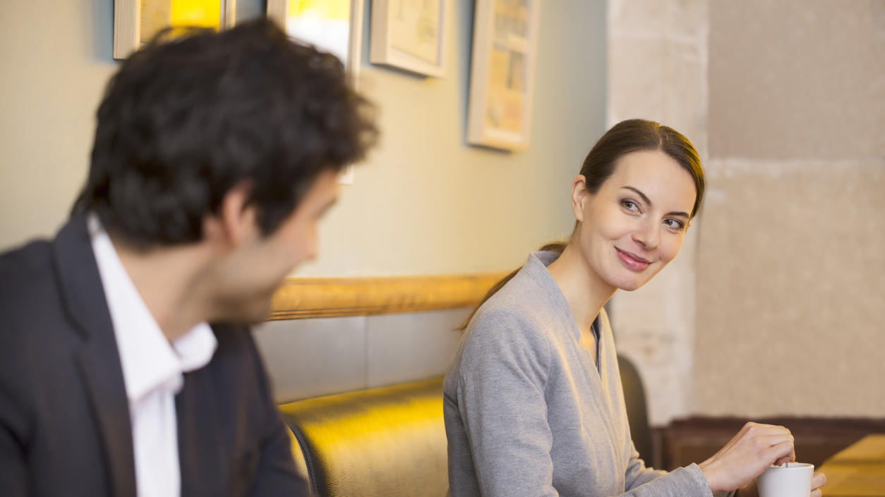 Frau flirtet mit Nebensitzer im Café