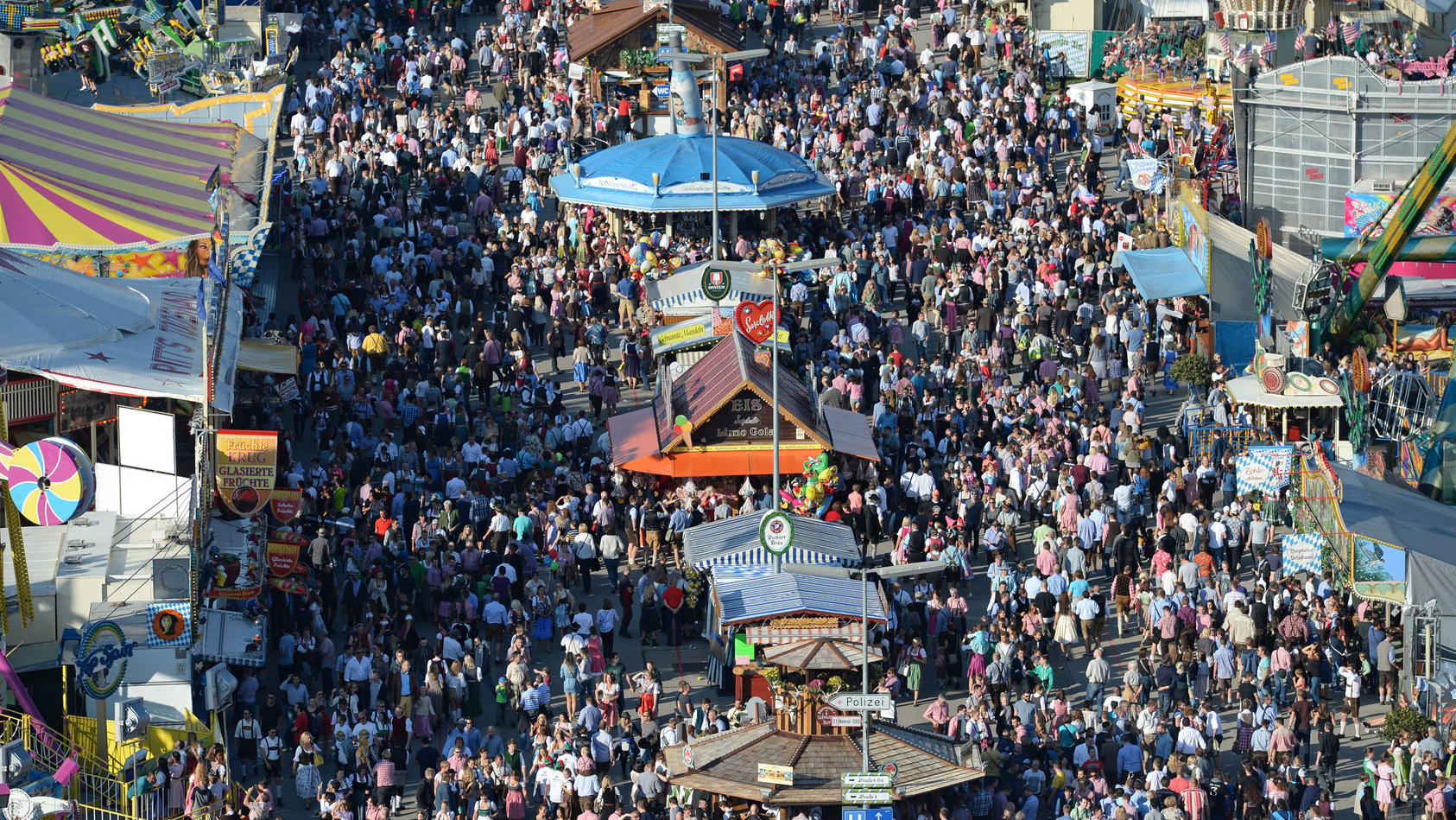 ARCHIV - 24.09.2016, Bayern, München: Zahlreiche Menschen gehen bei Sonnenschein über das Oktoberfest-Gelände. (zu dpa: «Countdown zur Wiesn zwischen Pandemie, Inflation und Energiekrise») Foto: picture alliance / dpa +++ dpa-Bildfunk +++