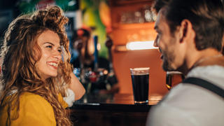 Frau und Mann flirten an einer Bar