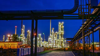 ARCHIV - 04.05.2022, Brandenburg, Schwedt: Die Anlagen der Erdölraffinerie auf dem Industriegelände der PCK-Raffinerie GmbH sind abends beleuchtet. (zu dpa "Regierung stellt Rosneft Deutschland unter Treuhandverwaltung") Foto: Patrick Pleul/dpa +++ dpa-Bildfunk +++