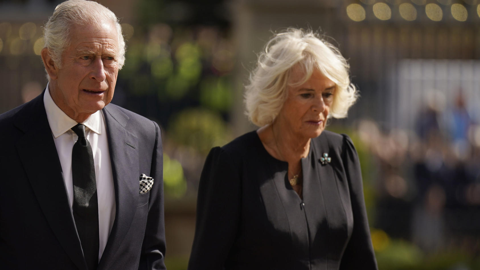 13.09.2022, Nordirland, Belfast: Der britische König Charles III. und seine Frau Camilla betrachten die Blumen vor dem Hillsborough Castle. Charles und Camilla besuchen zunächst eine Ausstellung über die lange Bindung von Queen Elizabeth II. mit Nord