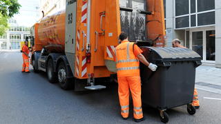 Mitarbeiter der Abfallwirtschaft Stuttgart beladen in der baden-württembergischen Landeshauptstadt Stuttgart einen Müllwagen (Foto vom 23.07.2012). 20 Tonnen Müll entsorgt ein Dreier-Team pro Tag.