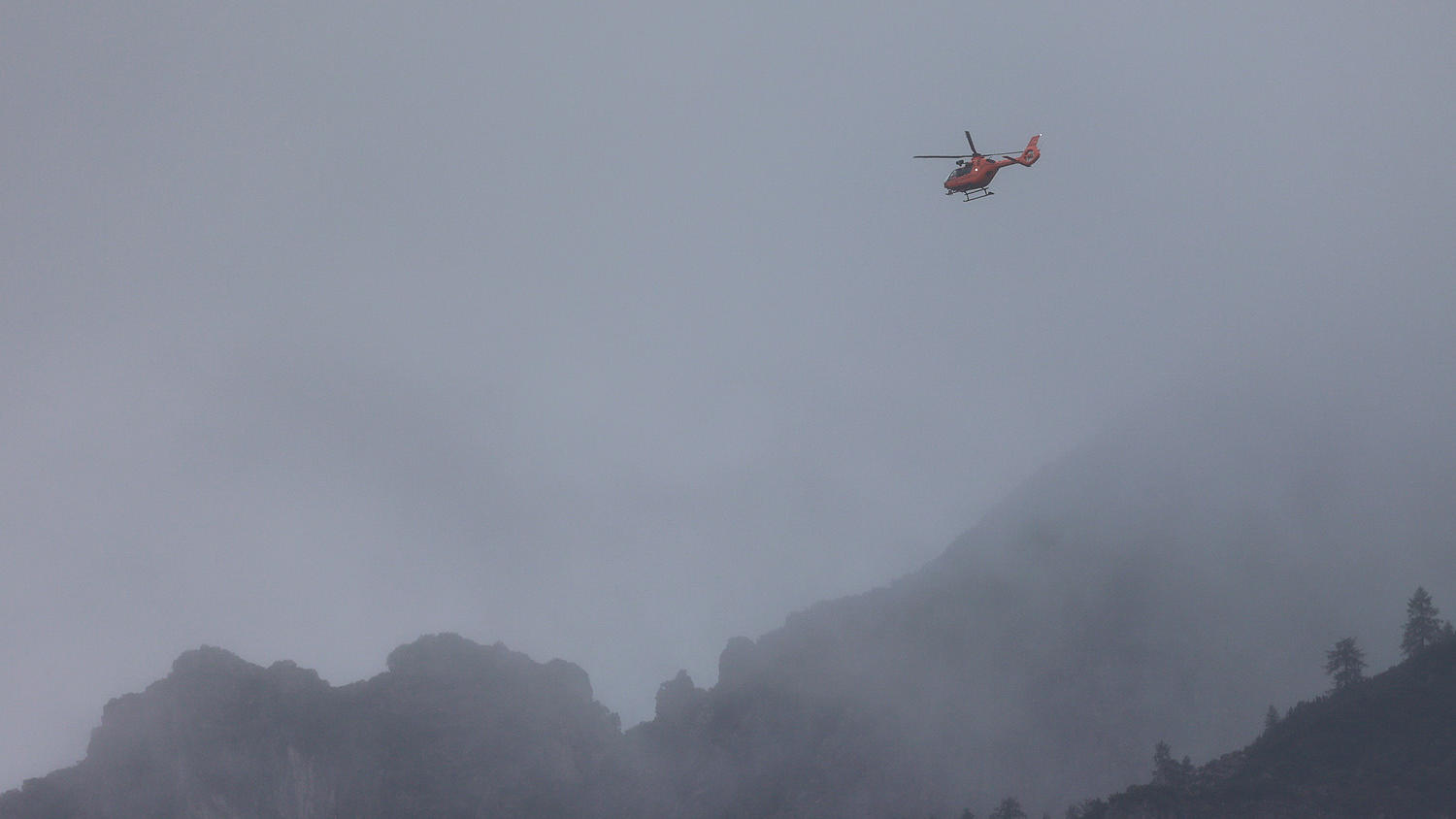 HANDOUT - 17.09.2022, Bayern, Ramsau: Mit einem Hubschrauber suchen Rettungskräfte der Bergwacht bei Berchtesgaden am Hochkalter nach einem vermissten Wanderer. Der 24-Jährige war am Samstag (17.09.2022) bei Schneefall zu einer hochalpinen Tour aufge