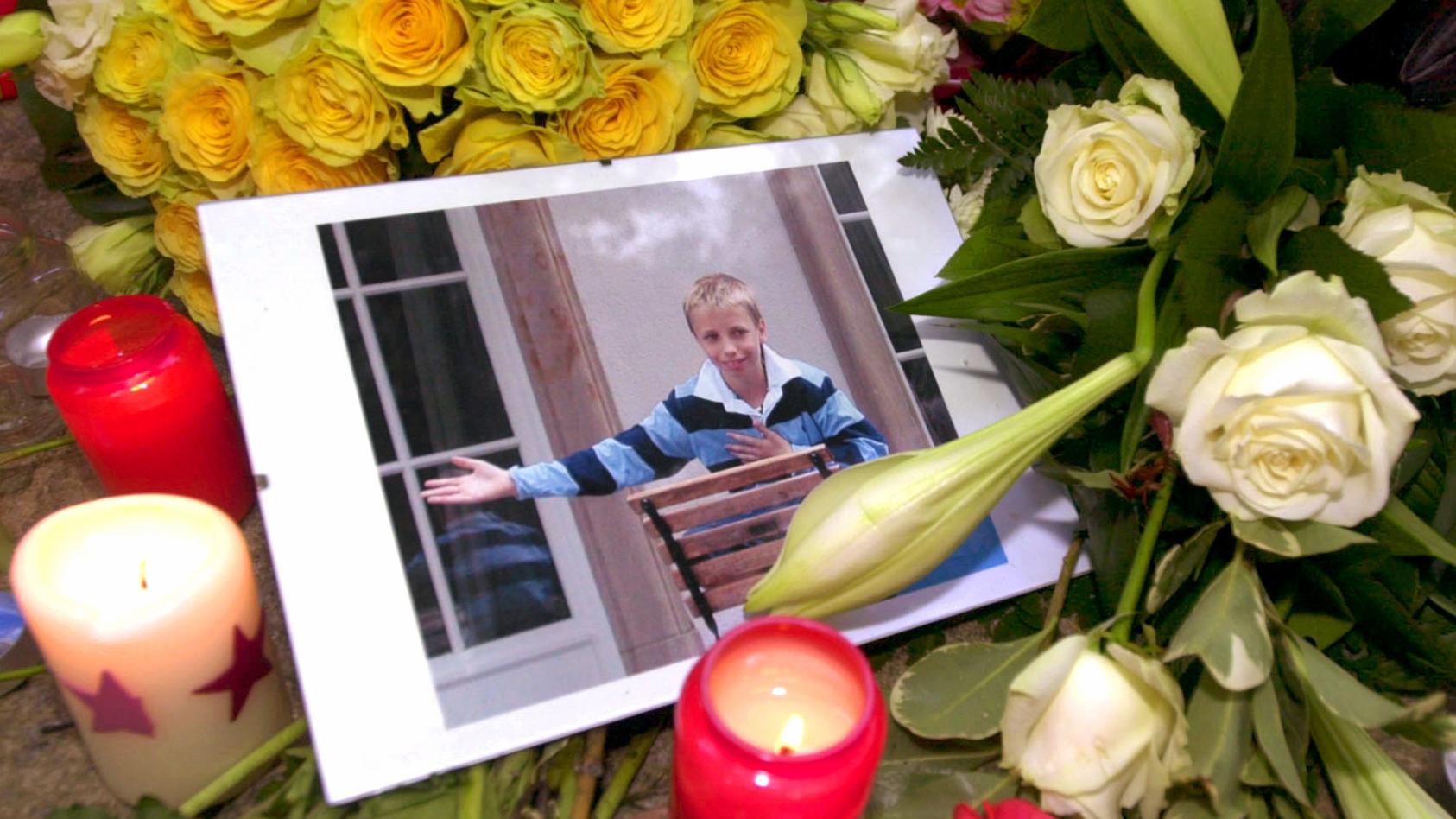 Inmitten von Blumengestecken und Kerzen liegt am 2.10.2002 vor dem Elternhaus des Mordopfers in Frankfurt am Main ein Bild des toten Jakob von Metzler. Die Leiche des Elfjährigen war am 1.10.2002 aus einem Waldsee bei Schlüchtern in Osthessen geborge