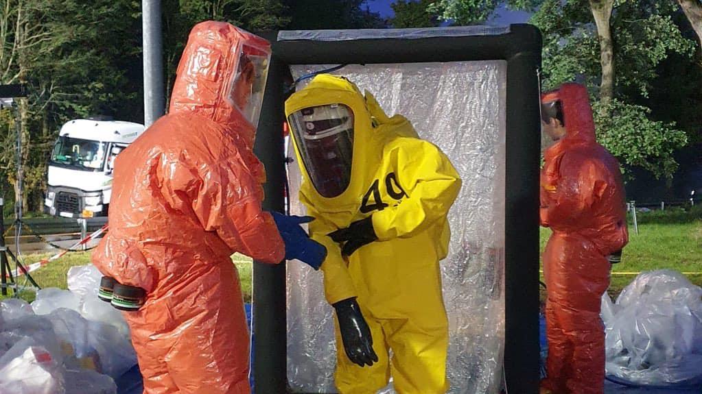 Einsatzkräfte tragen wegen der stark ätzenden Chemikalie Schutzanzüge. (Foto: Facebook Feuerwehr Köln)