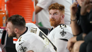 New Orleans Saints quarterback Andy Dalton (14) watches from the sideline next to Taysom Hill (7) during the second half of an NFL football game against the Arizona Cardinals, Thursday, Oct. 20, 2022, in Glendale, Ariz. (AP Photo/Matt York)